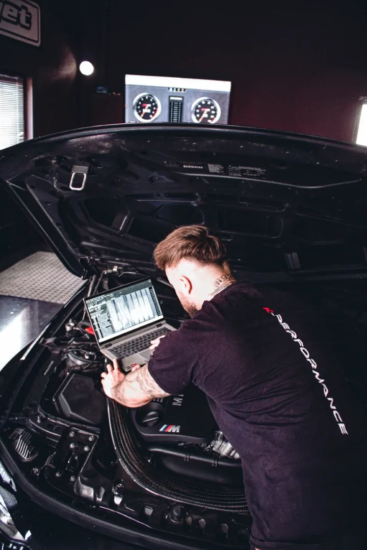 André Korn bei der Softwareoptimierung am BMW-Motor mit Laptop